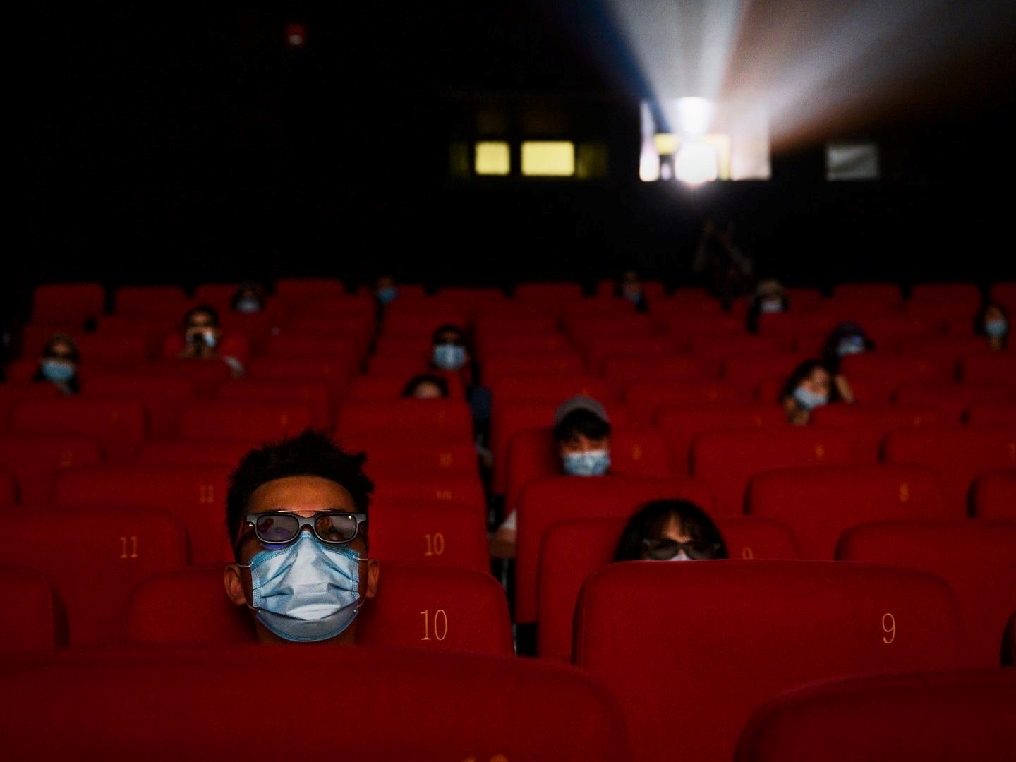 يرتدي الناس أقنعة واقية من كورونا أثناء مشاهدتهم فيلماً في سينما في بكين 24 تموز / يوليو (أ ف ب).