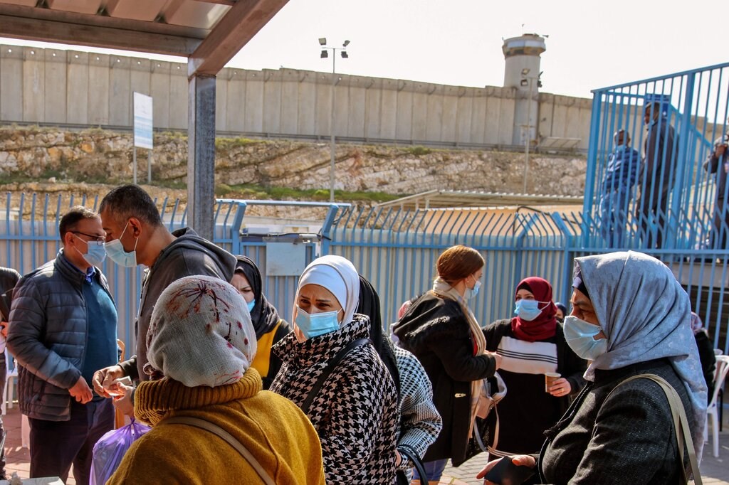 فلسطينيون ينتظرون على حاجز إسرائيلي قرب رام الله دورهم لتلقي لقاح كورونا.