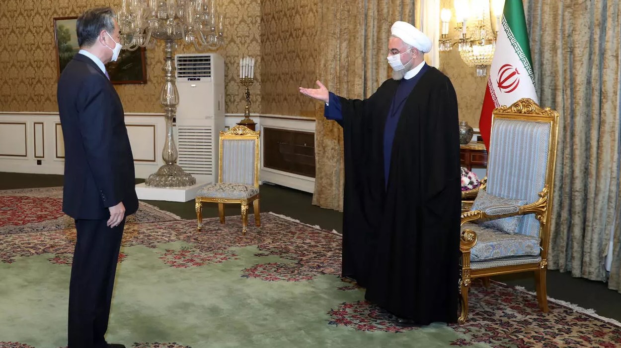 الرئيس الإيراني حسن روحاني أثناء استقباله وزير الخارجية الصيني وانغ يي (أ ف ب)