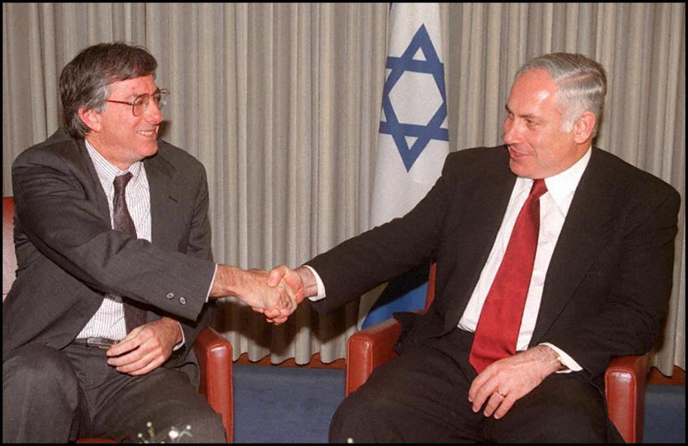 دينيس روس ونتنياهو يتصافحان في القدس المحتلة عام 1996 (أ ف ب).