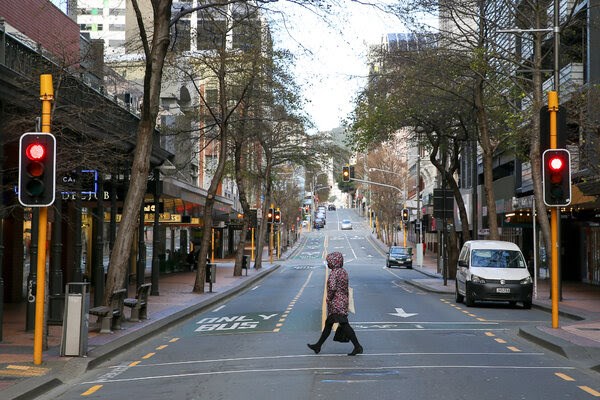 مواطنة نيوزيلندية تقطع الطريق في مدينة ويلينغتون وسط قيود الإغلاق.