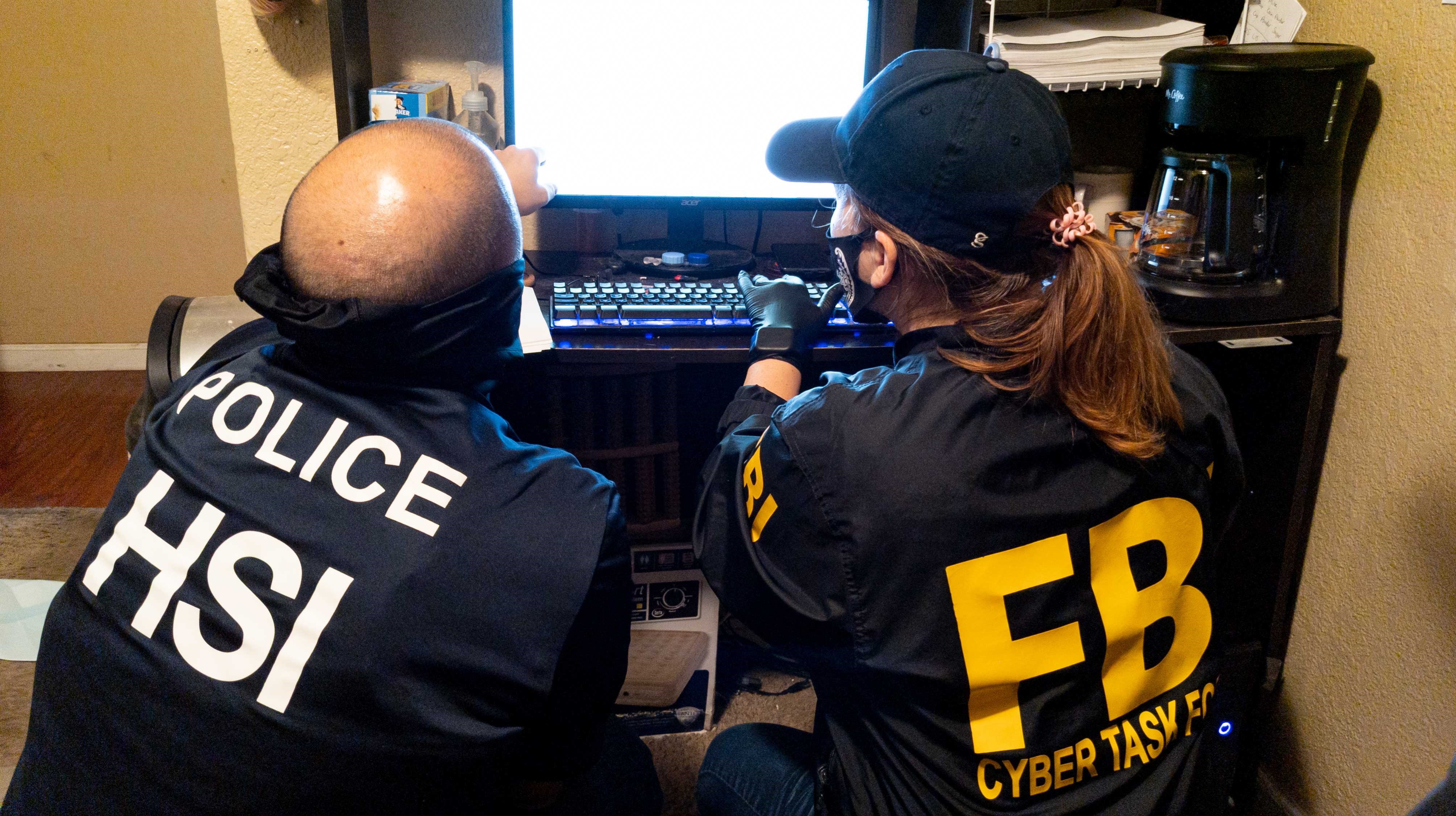محققون من مكتب التحقيقات الفيدرالي (FBI) يجرون عمليات بحث عبر الكمبيوتر