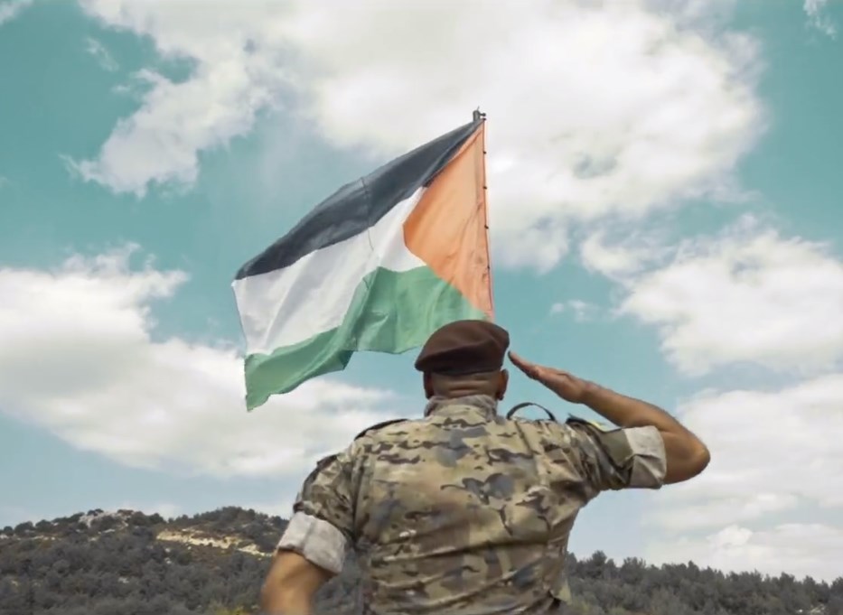 أحد عناصر حزب الله يؤدي التحية للعلم الفلسطيني - الإعلام الحربي 