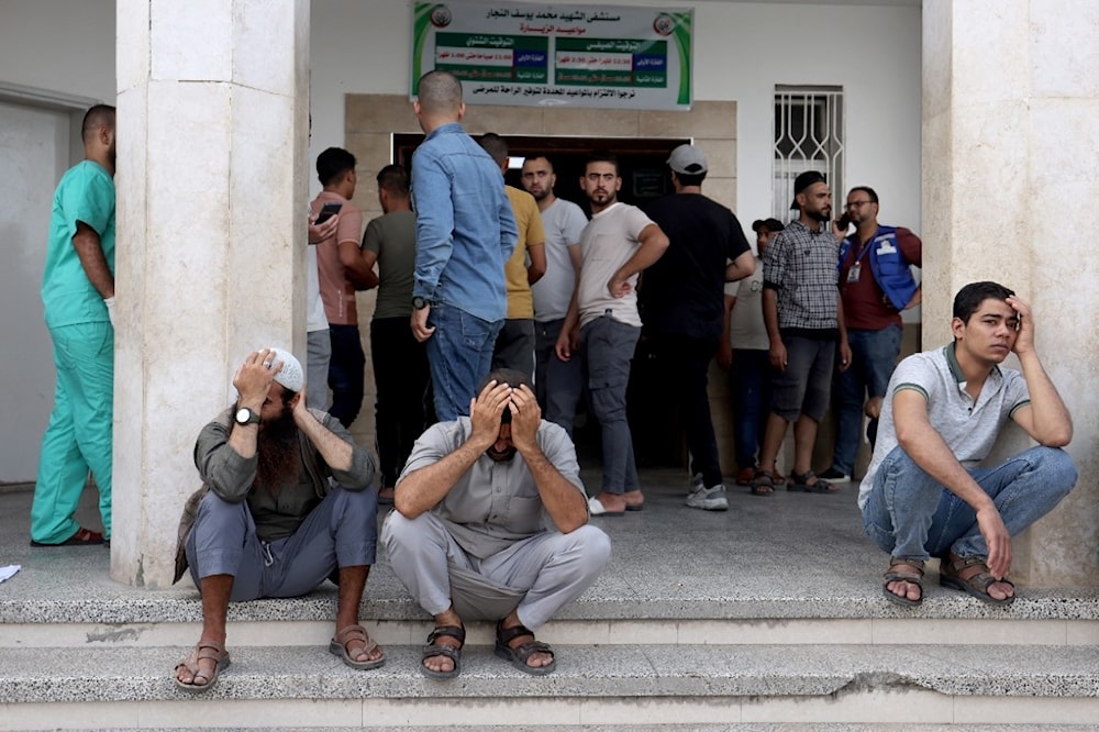 فلسطينيون في غزة على عتبة أحد مستشفيات رفح، جنوبي القطاع (أ ف ب)