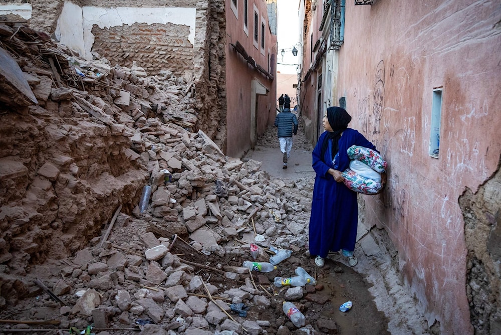 امرأة تنظر إلى أنقاض مبنى في المدينة القديمة التي دمرها الزلزال في مراكش (AFP)