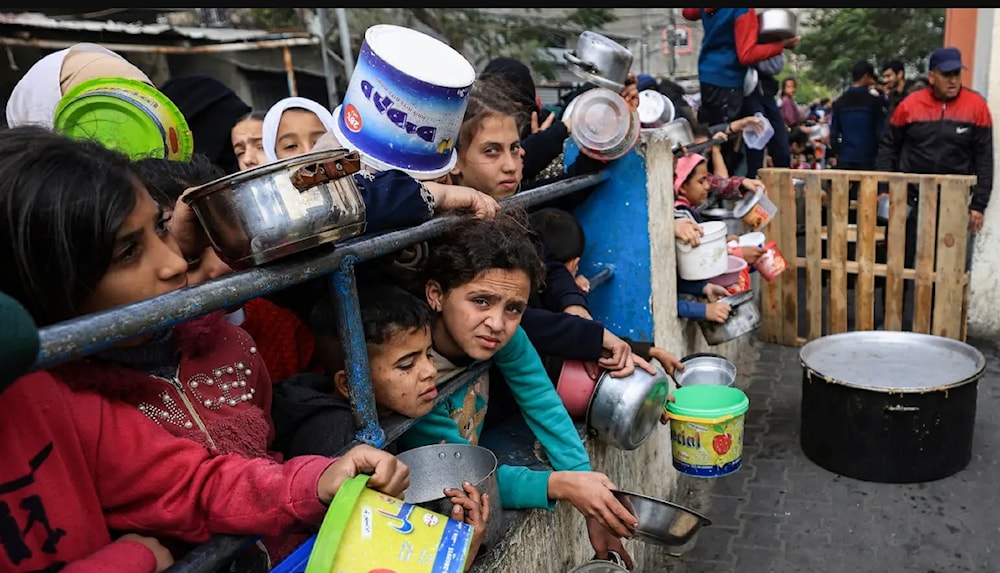 أطفال غزة يعانون من الجوع وينتظرون أن يوضع الطعام في دلوهم ليأكلوا قليلاً ولا ينامون ببطون خاوية