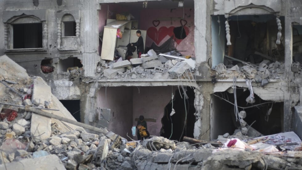 فلسطينيون ينظرون إلى الدمار الناجم عن القصف الإسرائيلي لقطاع غزة في رفح، 12 شباط/فبراير 