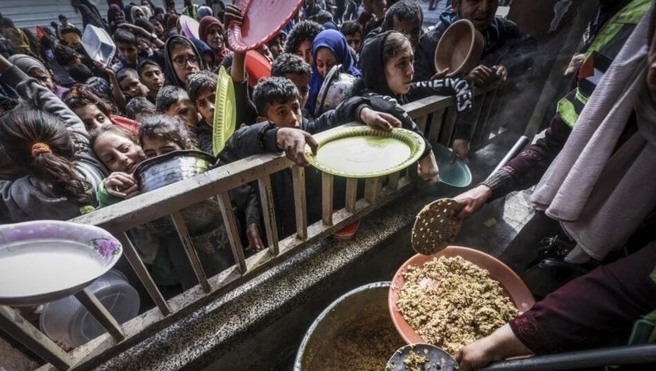 أطفال فلسطينيون نازحون يتجمعون للحصول على الطعام وسط مخاوف من انتشار المجاعة (أ ف ب)