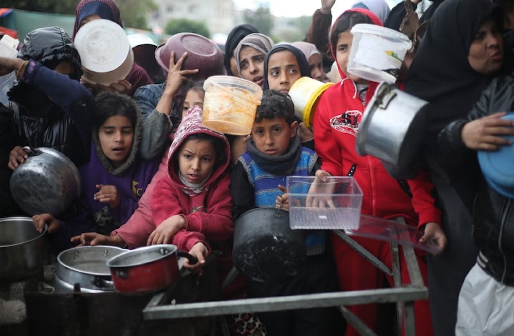 فلسطينيون يحاولون الحصول على وجبات طعام في خان يونس في ظل استمرار العدوان الإسرائيلي ضد القطاع (أرشيف)