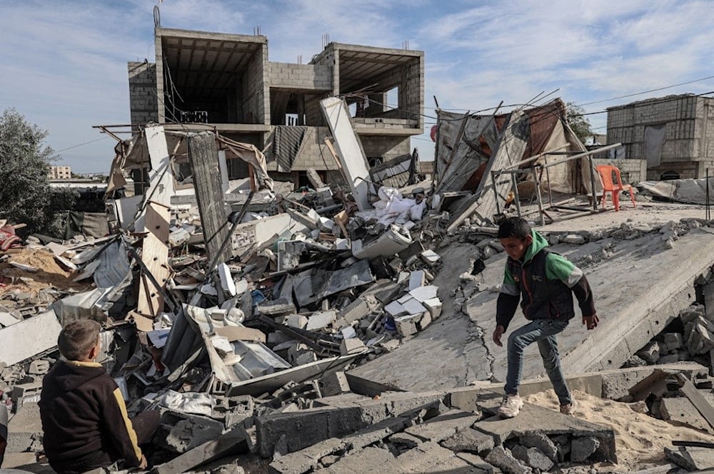 صبية فلسطينيون وسط أنقاض منزل دمره قصف الاحتلال شمالي رفح جنوبي قطاع غزة 23 آذار/مارس 2024 (أ ف ب) 