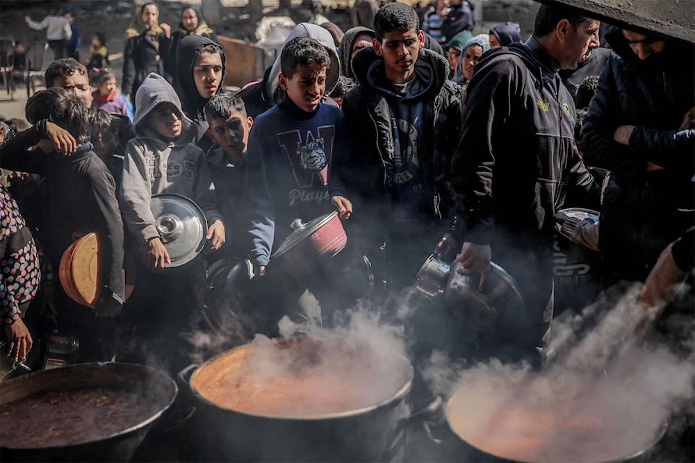 فلسطينيون يتجمّعون للحصول على المساعدات الغذائية في بيت لاهيا، شمالي قطاع غزة، وسط حرب التجويع التي يمارسها الاحتلال (أرشيفية - أ ف ب)