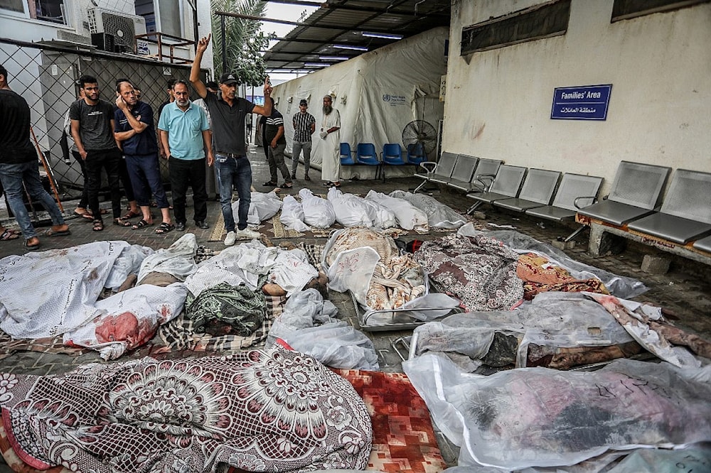 فلسطينيون ينتظرون استلام جثث أقاربهم الذين استشهدوا في غارة جوية إسرائيلي على رفح، جنوب قطاع غزة في 24 تشرين الأول/أكتوبر 2023 (عبد الرحيم الخطيب)