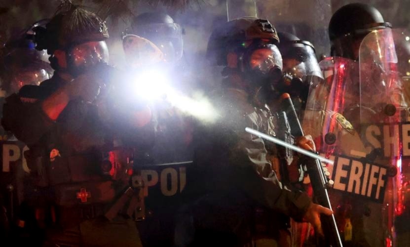 شرطي يطلق غازات مسيلة للدموع باتجاه طلاب مؤيدين لفلسطين في حرم جامعة أريزونا في الولايات المتحدة الأميركية يوم الجمعة (أسوشيتد برس)