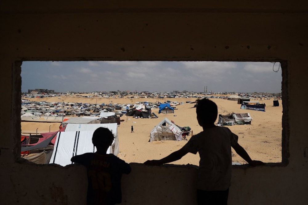 أطفال فلسطينيون يقفون في مخيم للنازحين في رفح جنوبي قطاع غزة - 28 نيسان/أبريل 2024 (AFP)