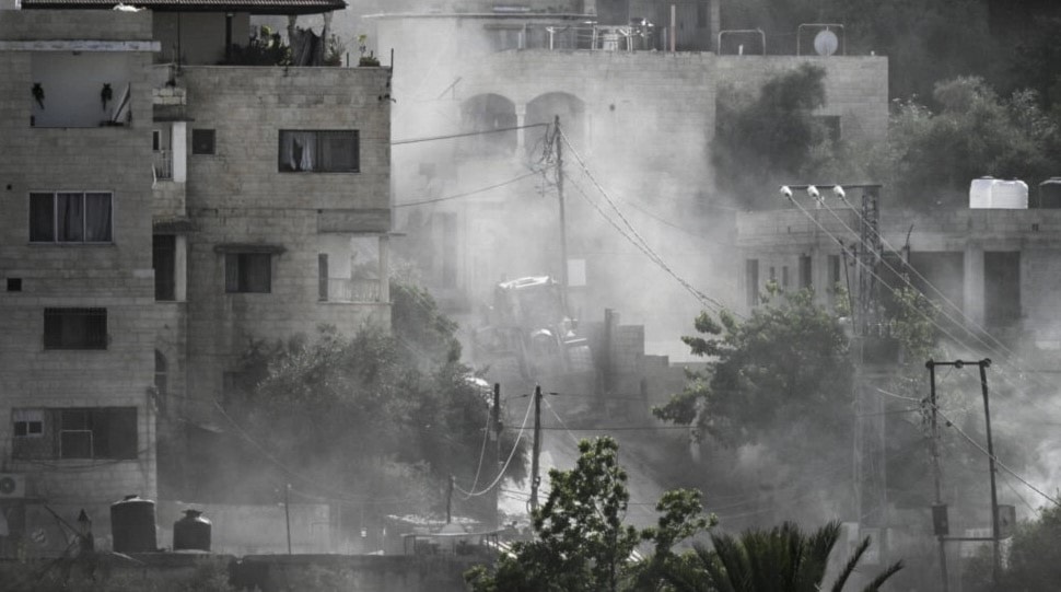 جرّافة عسكرية إسرائيلية وسط دخان ناتج عن قصف لـ