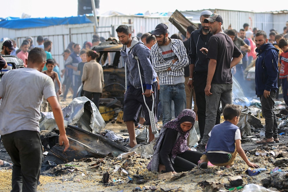 فلسطينيون يتجمعون في موقع غارة إسرائيلية على مخيم للنازحين في رفح 27 أيار/مايو 