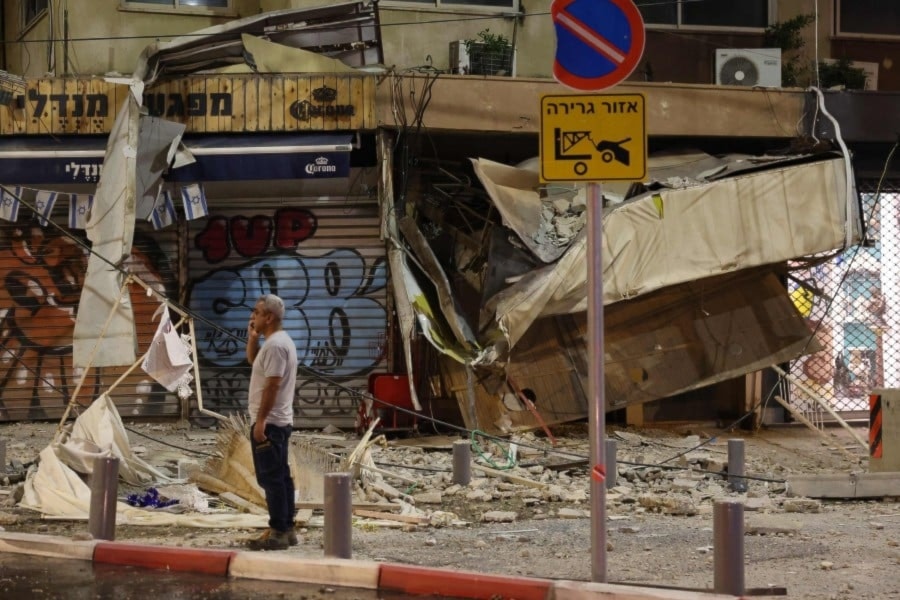 إسرائيلي يقف أمام متجر متضرر في 