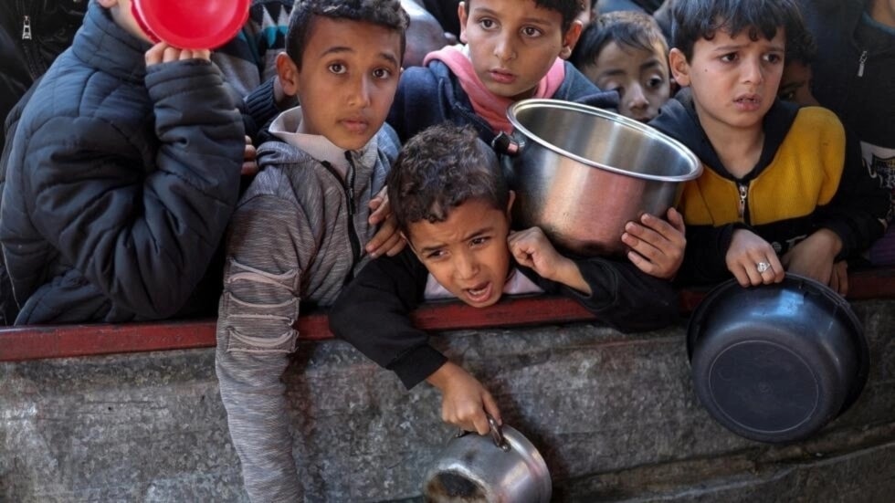 أطفال فلسطينيون ينتظرون الحصول على طعام في رفح جنوبي قطاع غزّة (وكالات)