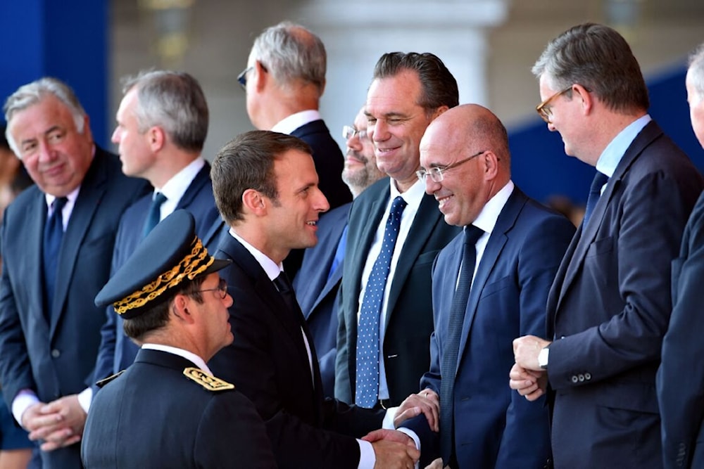 رئيس حزب الجمهوريين اليميني إريك سيوتي يصافح الرئيس الفرنسي إيمانويل ماكرون
