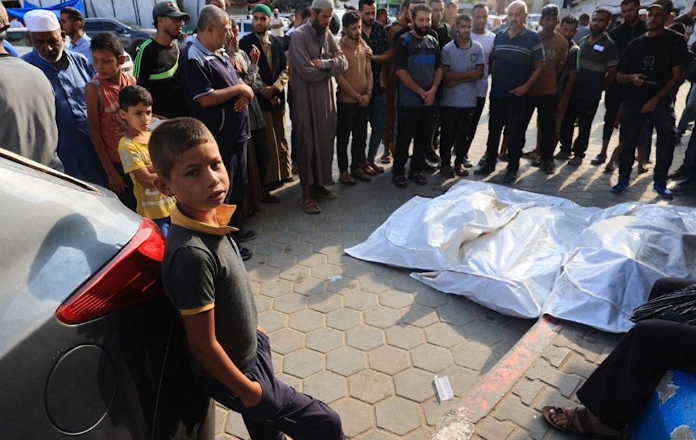 فلسطينيون يصلون على جثث الشهداء في ساحة مستشفى شهداء الأقصى في دير البلح - 7 تموز/يوليو 2024 (أ ف ب)