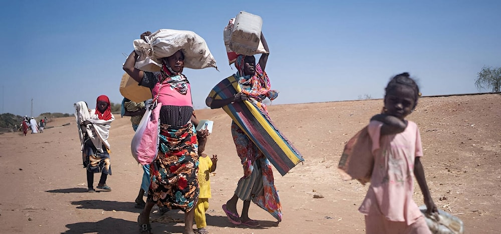 نساء وفتيات ينزحن من إحدى المناطق من جراء الصراع الدائر في السودان