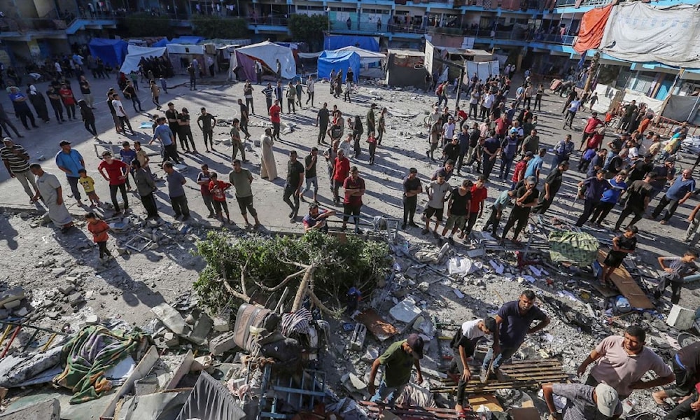 فلسطينيون يبحثون عن أحياء بين أنقاض مدرسة تؤوي نازحين دمّرها الاحتلال في النصيرات وسط قطاع غزة (وكالات)