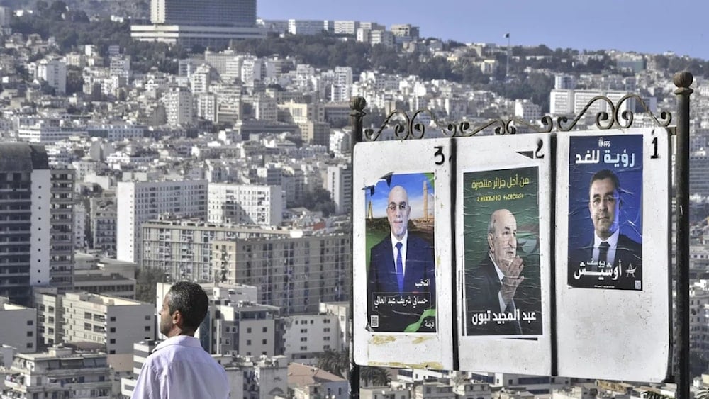 لوحة طرقية تضمّ صوراً للمرشحين الثلاثة للانتخابات الرئاسية في الجزائر لعام 2024 (وكالات)