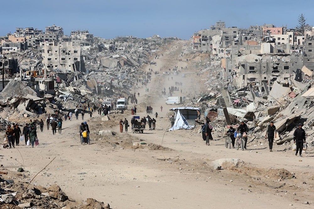 فلسطينيون يسيرون في أحد شوارع جباليا على طول أنقاض المباني المدمرة في اليوم الثالث من اتفاق وقف إطلاق النار - 21 كانون الثاني/يناير 2025 (أ ف ب)