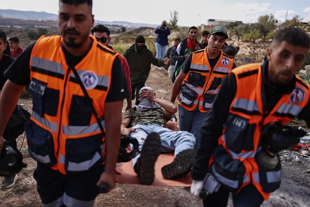 فرق إنقاذ فلسطينية تنقل مصاباً في مواجهة مع قوات الاحتلال الإسرائيلي قرب سجن عوفر (أ ف ب)