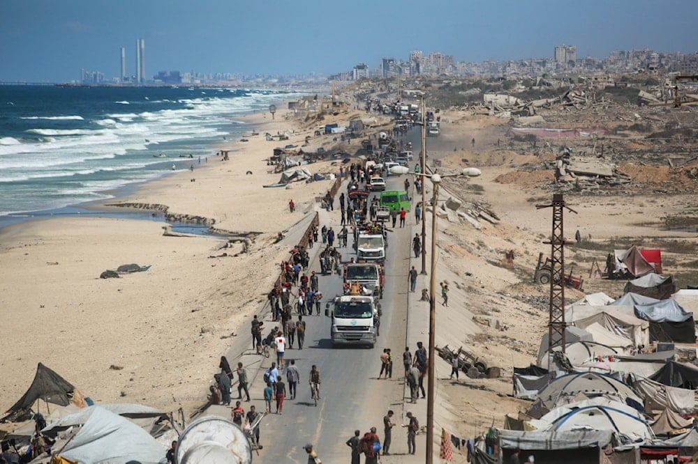 فلسطينيون يحملون أمتعتهم عند الطريق الساحلي شمال غرب مخيم النصيرات عقب إعلان الاحتلال إغلاق طريق الرشيد المؤدي إلى شمالي قطاع غزة المحاصر (أ ف ب)