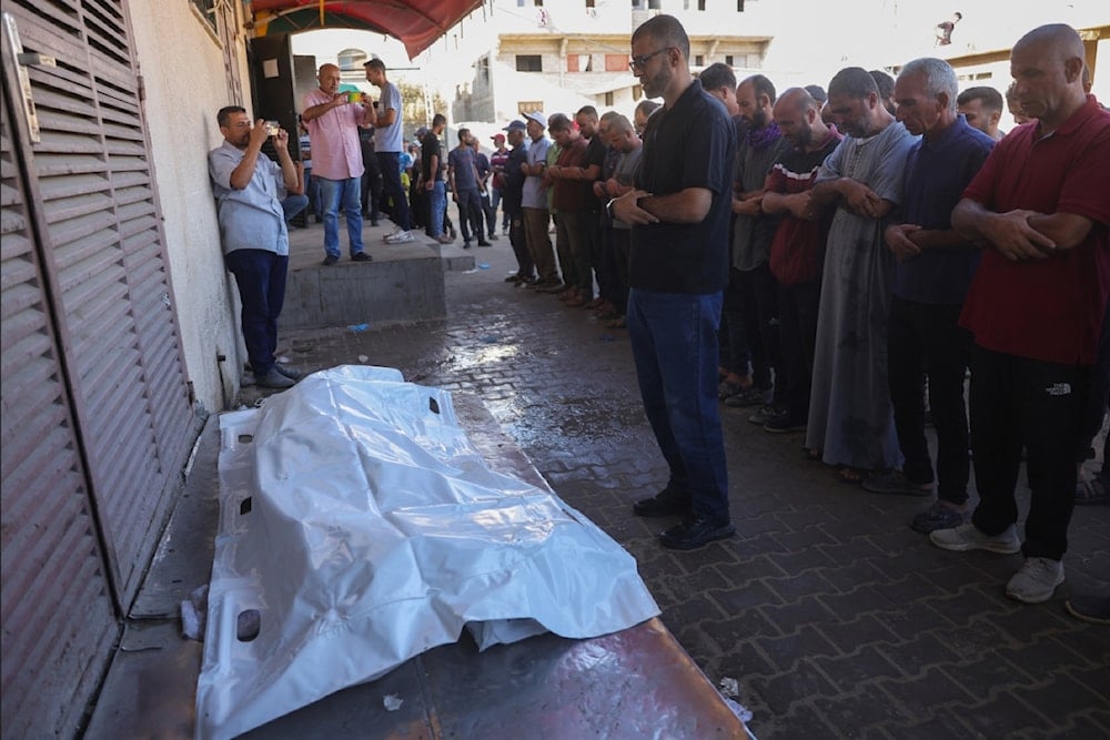 فلسطينيون يصلون صلاة الجنازة على شهيد استهدفه الاحتلال الإسرائيلي في دير البلح في مستشفى شهداء الأقصى وسط قطاع غزة (أ ف ب)