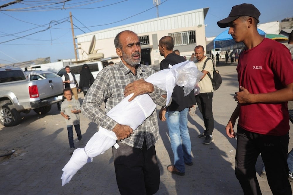 فلسطيني يحمل جثمان طفل استشهد بغارة للاحتلال في دير البلح 20 تشرين الأول/أكتوبر 2025 (أ ف ب)