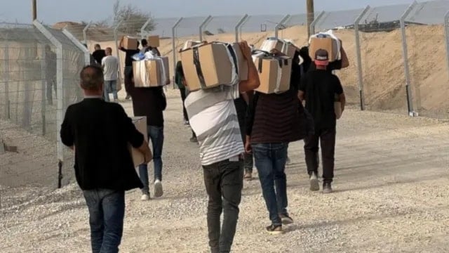 فلسطينيون يحملون المساعدات عند خروجهم من أحد مراكز مؤسسة غزة الانسانية (أرشيفية)