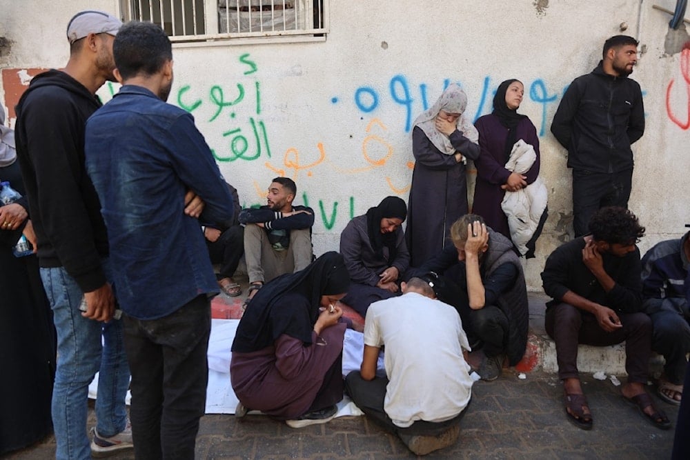 فلسطينيون يشيعون جثمان أحد أقاربهم الذي قتل في غارات إسرائيلية ليلية، في مستشفى الشفاء بمدينة غزة (أ ف ب)