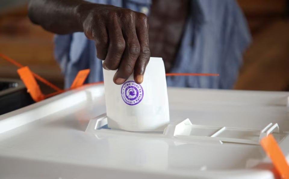 رجل يدلي بصوته خلال الانتخابات العامة في مركز اقتراع بدار السلام في تنزانيا (رويترز)