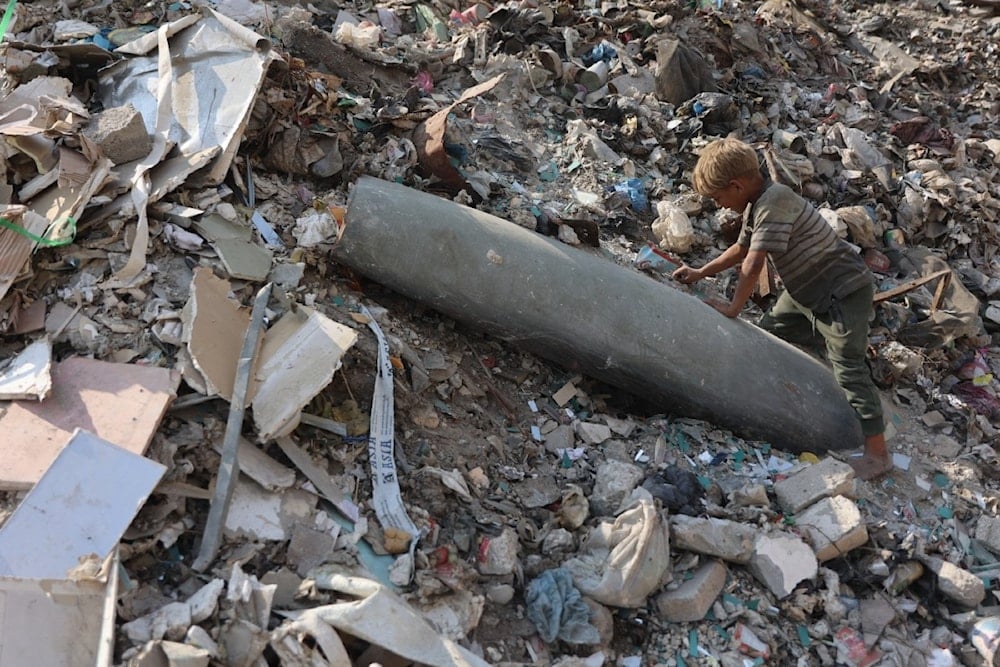 طفل فلسطيني يراقب صاروخاً إسرائيلياً غير منفجر في منطقة سوق فراس في مدينة غزة (أ ف ب)