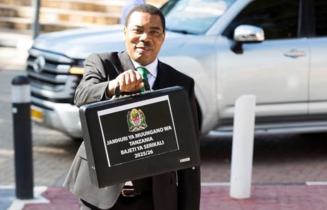وزير المالية في تنزانيا مويغولو نشيمبا يحمل حقيبة تحتوي على ميزانية الحكومة للسنة المالية 2025/2026 (رويترز)