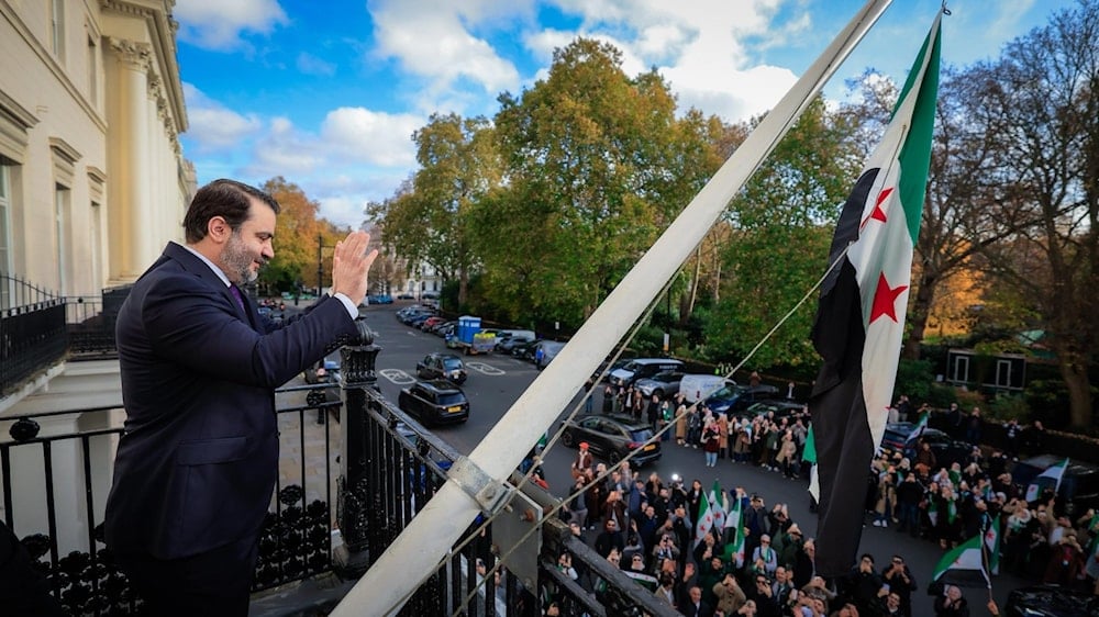 وزير الخارجية في الحكومة الانتقالية السورية أسعد الشيباني يرفع علم سوريا خلال إعادة افتتاح السفارة السورية في لندن (تواصل اجتماعي)