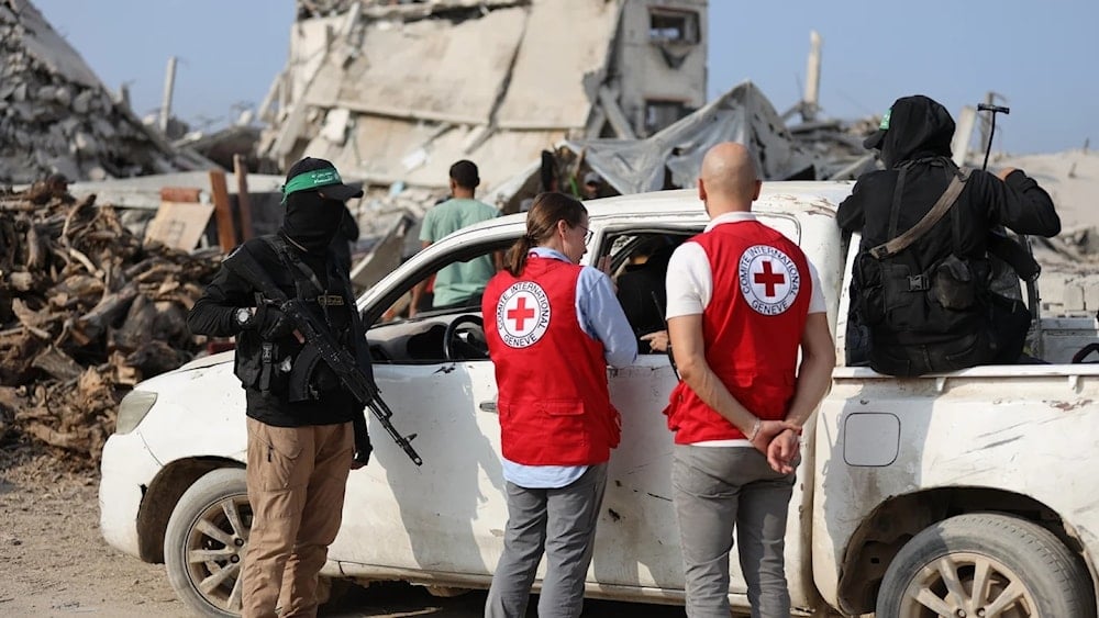 عناصر من كتائب القسام مع مسؤولين في الصليب الأحمر خلال عمليات البحث لاستعادة جثث الأسرى الإسرائيليين 13 تشرين الثاني/نوفمبر 2025 (أ ف ب)