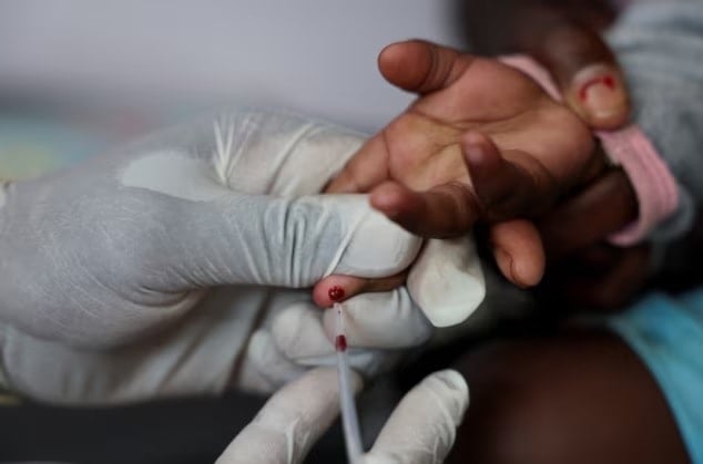 ممرضة تسحب عينة دم من طفل لإجراء اختبار فيروس 