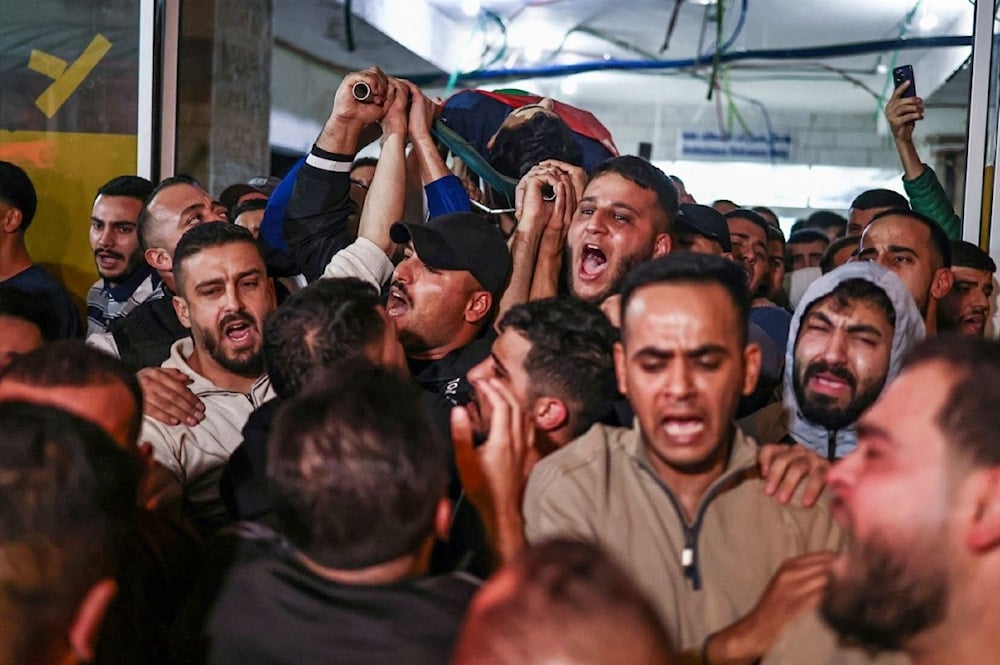 مشيعون يحملون جثمان الشهيد براء معالي خارج المستشفى الحكومي في رام الله في الضفة الغربية المحتلة - 23 تشرين الثاني/نوفمبر 2025 (أ ف ب)