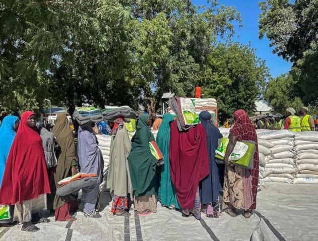 نساء نازحات بسبب الفيضانات يصطففن للحصول على الطعام في مايدوجوري بنيجيريا 2024 (رويترز)
