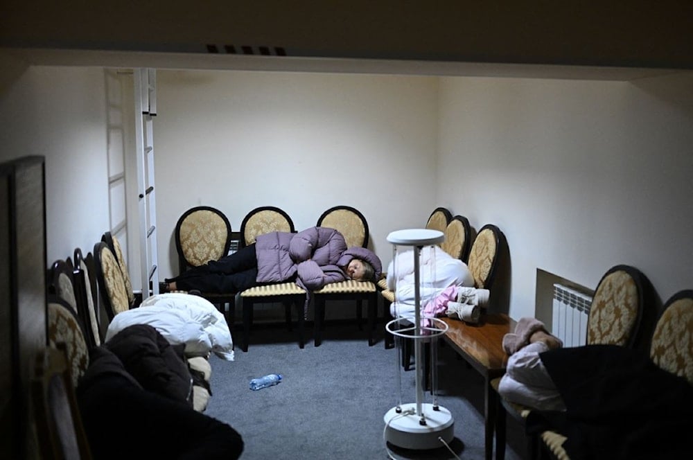 أشخاص يستلقون على كراسي في ملجأ فندق تحت الأرض خلال غارة جوية في كييف - فجر 25 تشرين الثاني/نوفمبر 2025 (أ ف ب)