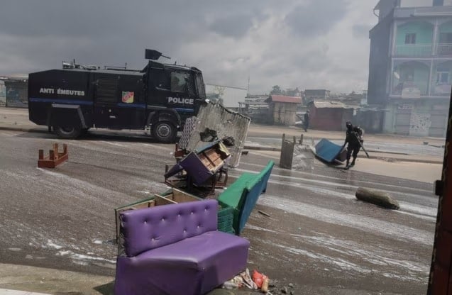 عنصر من قوات الأمن يزيل الحواجز خلال الاشتباكات مع أنصار مرشح المعارضة الكاميروني عيسى تشيروما في دوالا في الكاميرون (رويترز)