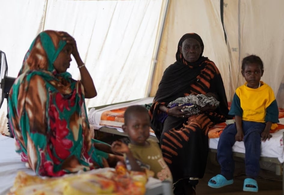 امرأة فرّت من العنف في الفاشر مع عائلتها إلى مكان آمن في طويلة بشمال دارفور السودان (رويترز)