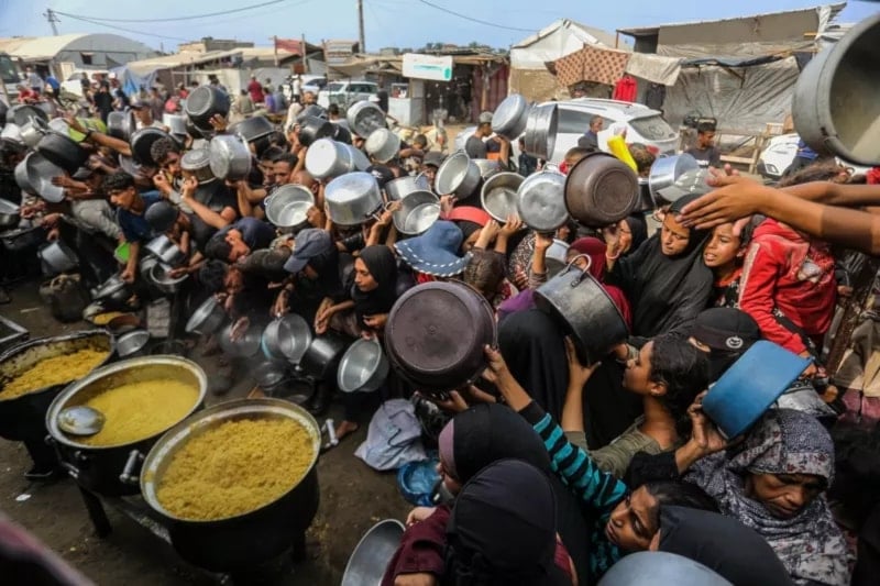 عشرات الفلسطينيين يجتمعون لاستلام المساعدات الغذائية في منطقة مواصي خان يونس، في 7 تشرين الثاني/نوفمبر 2025 (الأناضول)