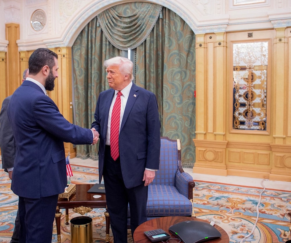 الرئيس الأميركي دونالد ترامب وهو يصافح الرئيس السوري الانتقالي أحمد الشرع في الرياض - 14 أيار/مايو 2025 (أ ف ب)