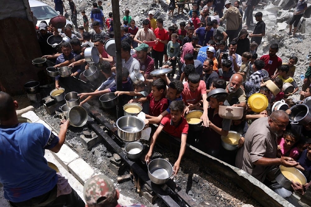 نازحون غزيون يحاولون الحصول على طعام في جباليا، في ظل تفاقم أزمة الجوع بفعل منع الاحتلال الإسرائيلي دخول المساعدات (أ ف ب)