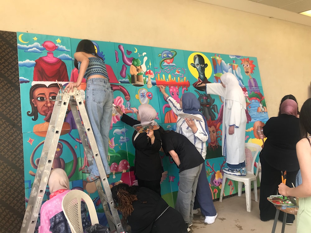  أثناء العمل على الجدارية وإنجازها