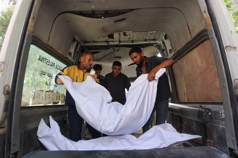مسعفون يخرجون جثامين شهداء في غارات إسرائيلية في مستشفى الشفاء في مدينة غزة - 26 أيار/مايو 2025 (أ ف ب)